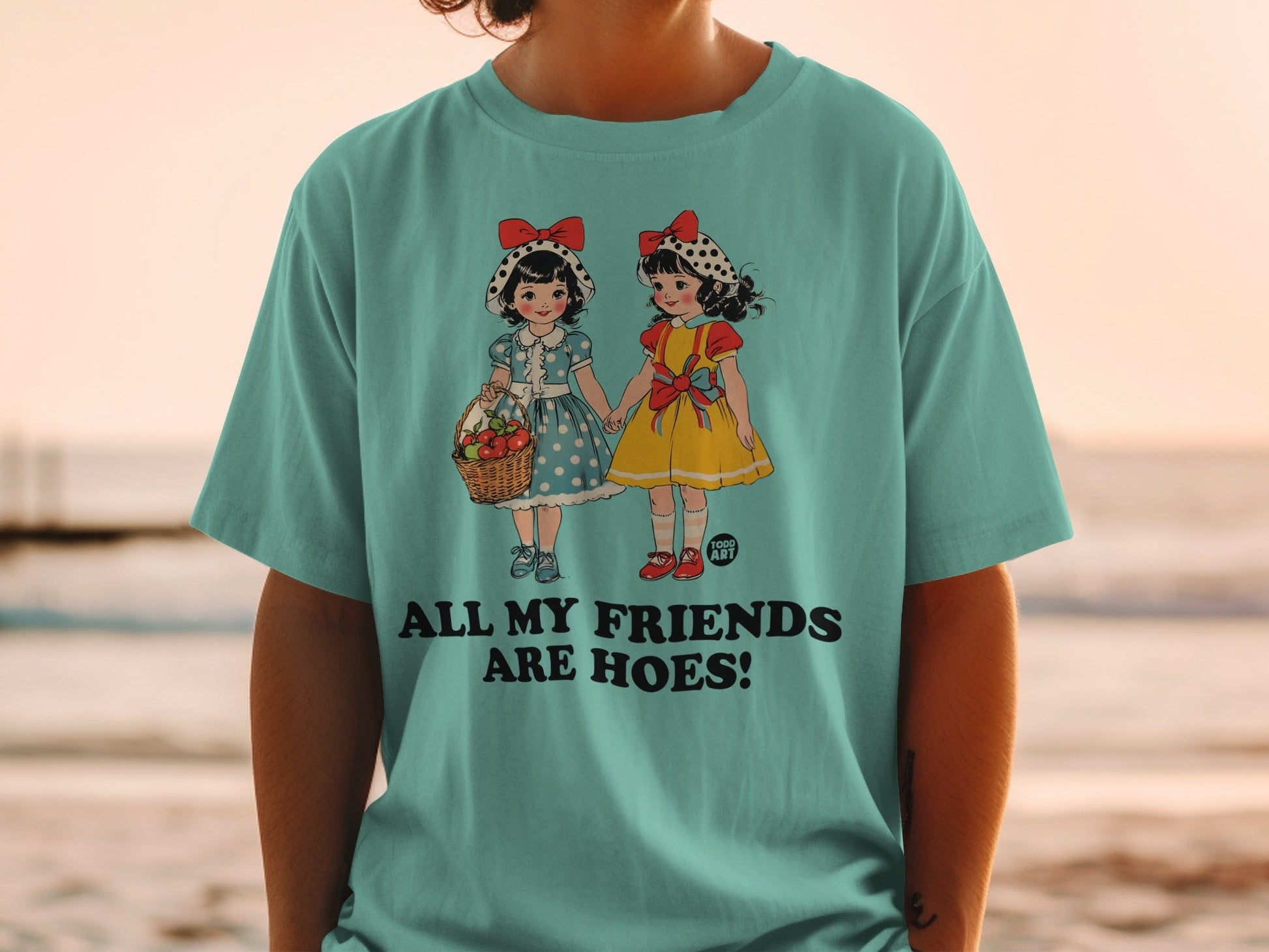 Teal t-shirt with retro cartoon girls holding hands and text.
