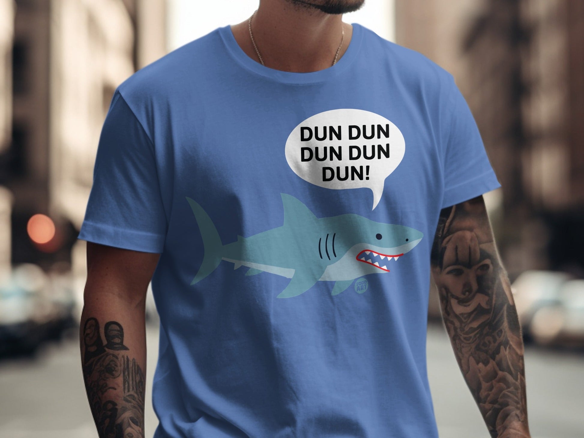 Blue t-shirt with cartoon shark and "DUN DUN DUN DUN!" speech bubble.