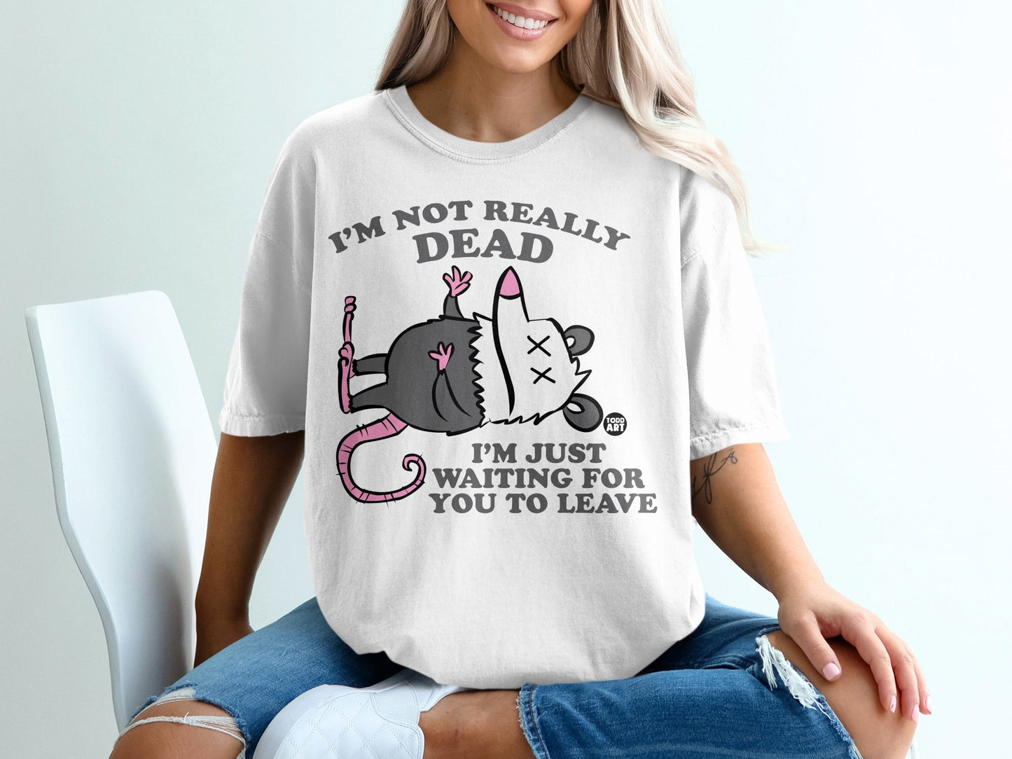White t-shirt with cartoon possum and text "I'm not really dead, I'm just waiting for you to leave."