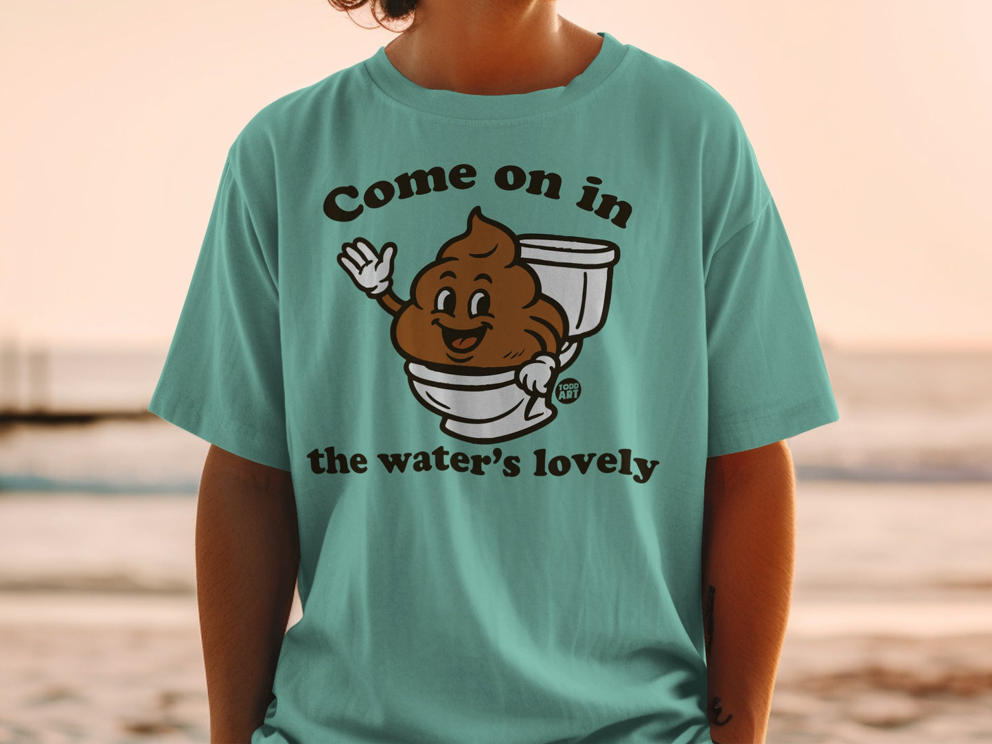 T-shirt with smiling cartoon poop in a toilet, text says "Come on in the water's lovely."