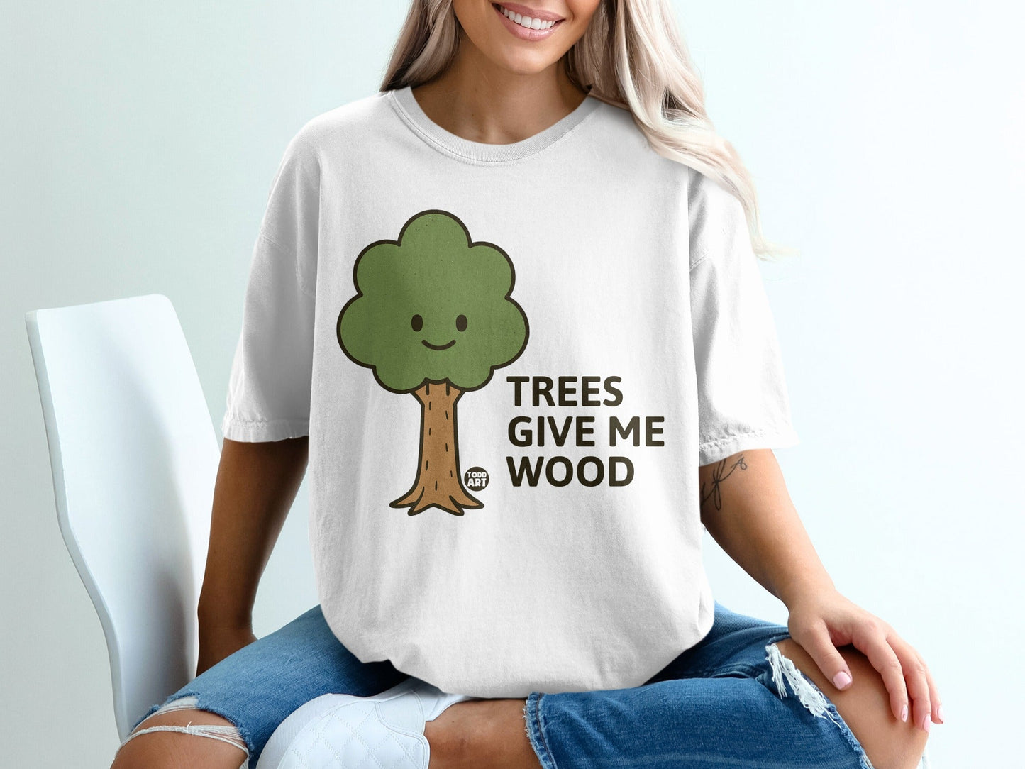 White t-shirt with cartoon tree and text "TREES GIVE ME WOOD".