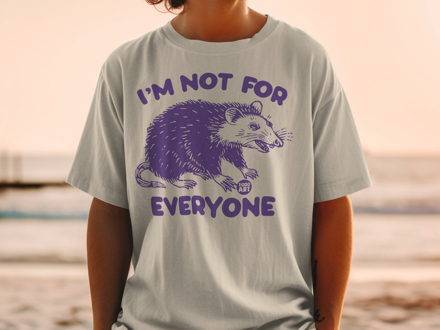 Light gray t-shirt with purple opossum graphic and "I'm not for everyone" text.