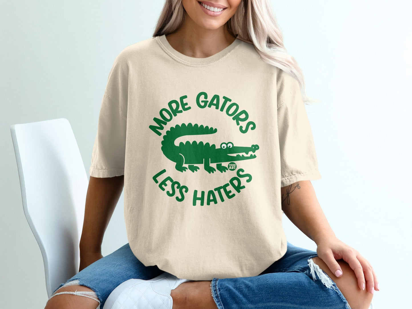 Cream t-shirt with green "More Gators Less Haters" graphic and alligator design.