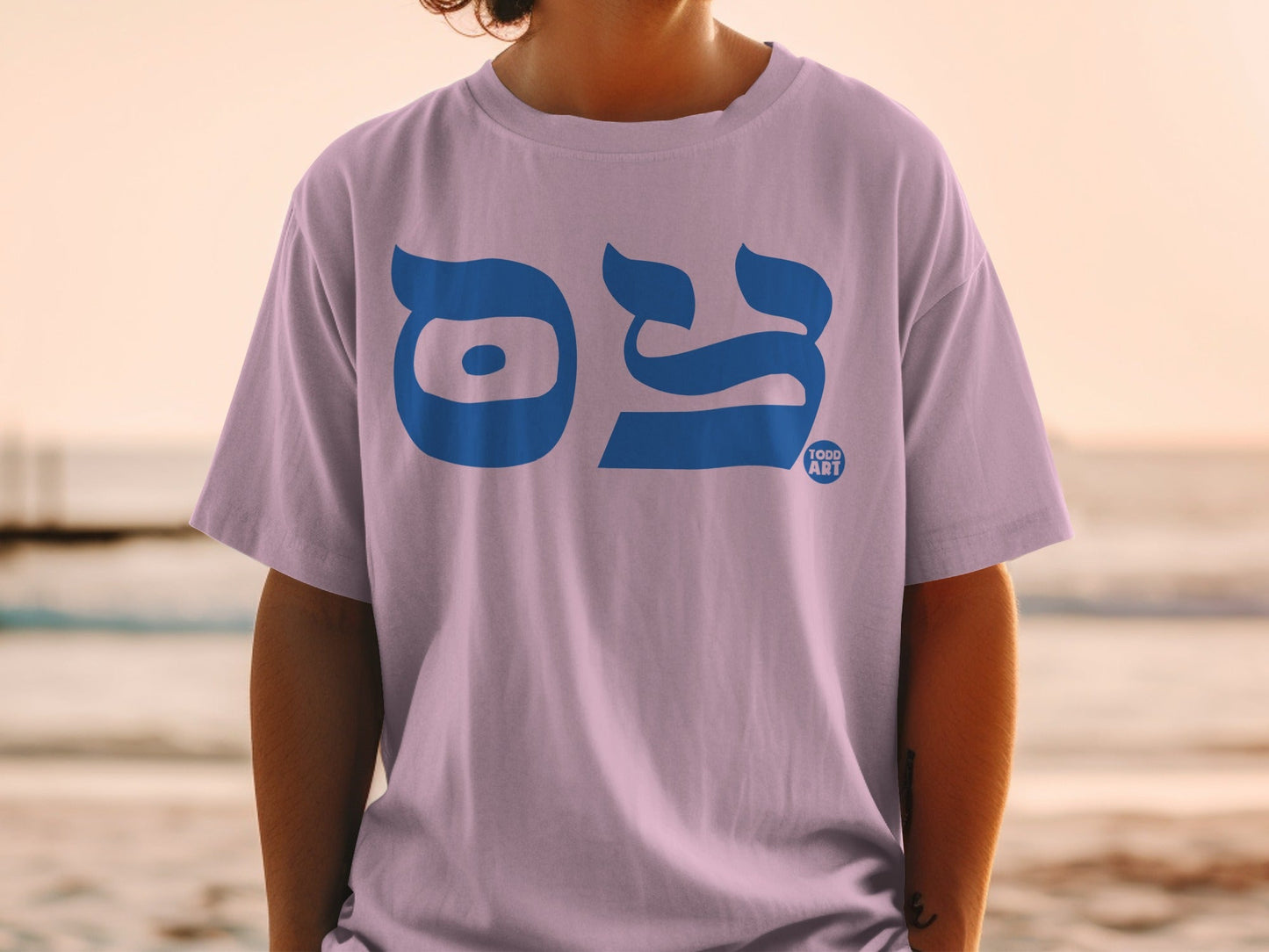 Light purple t-shirt with blue Hebrew text and "TODD ART" logo.