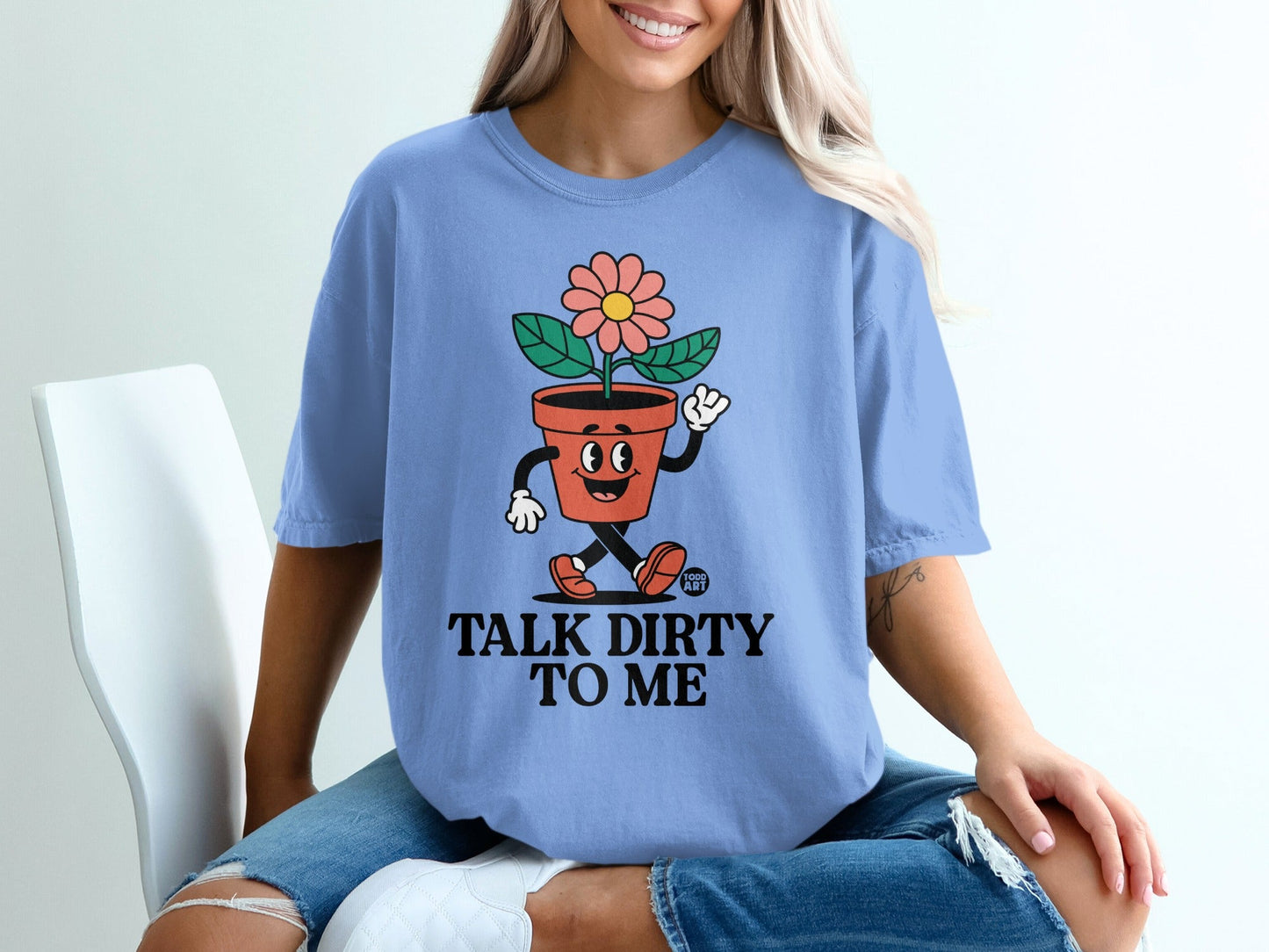 Light blue t-shirt with a potted plant character and text "TALK DIRTY TO ME".