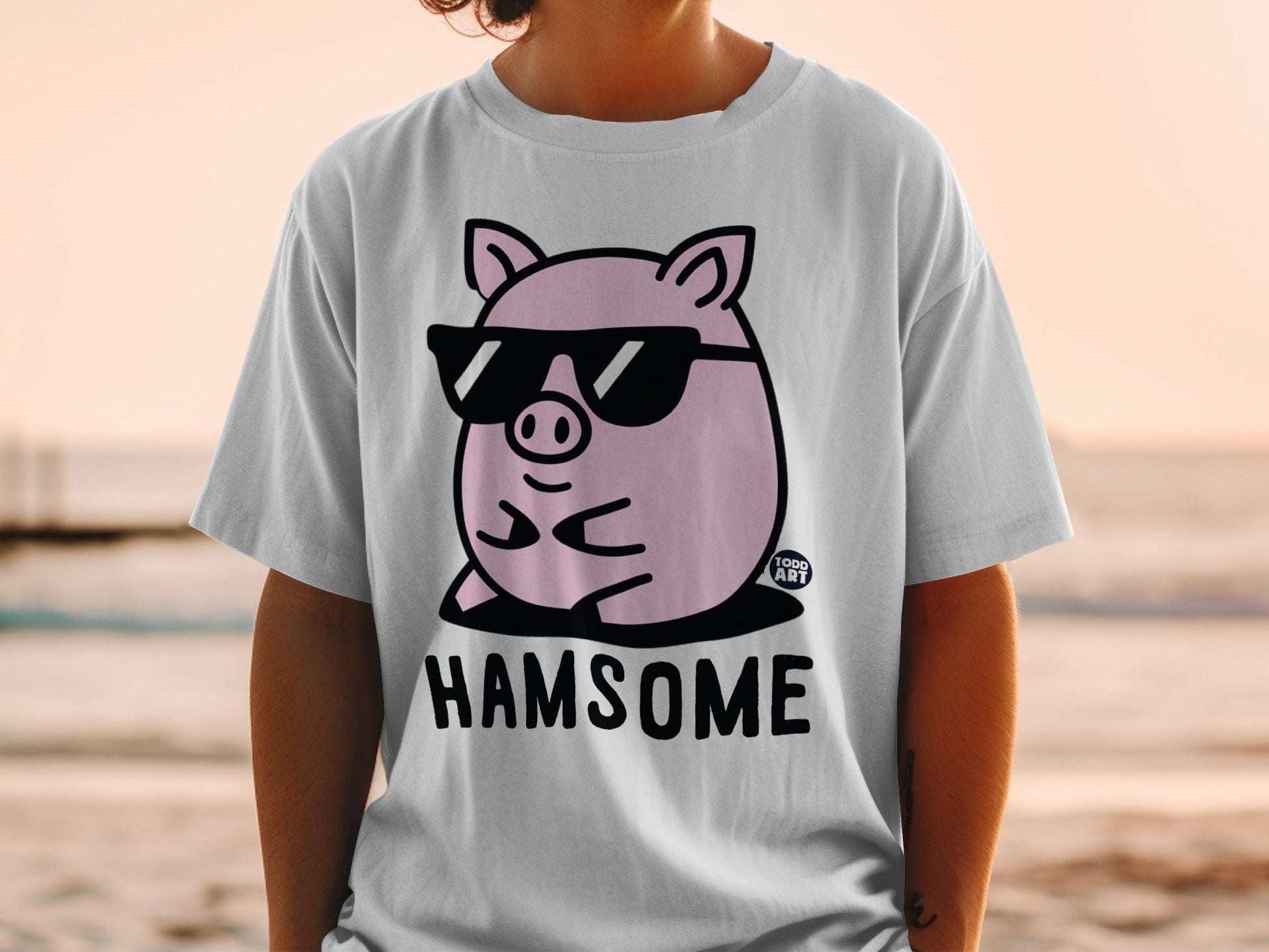 Pink pig wearing sunglasses with the text "HAMSOME" on a t-shirt.