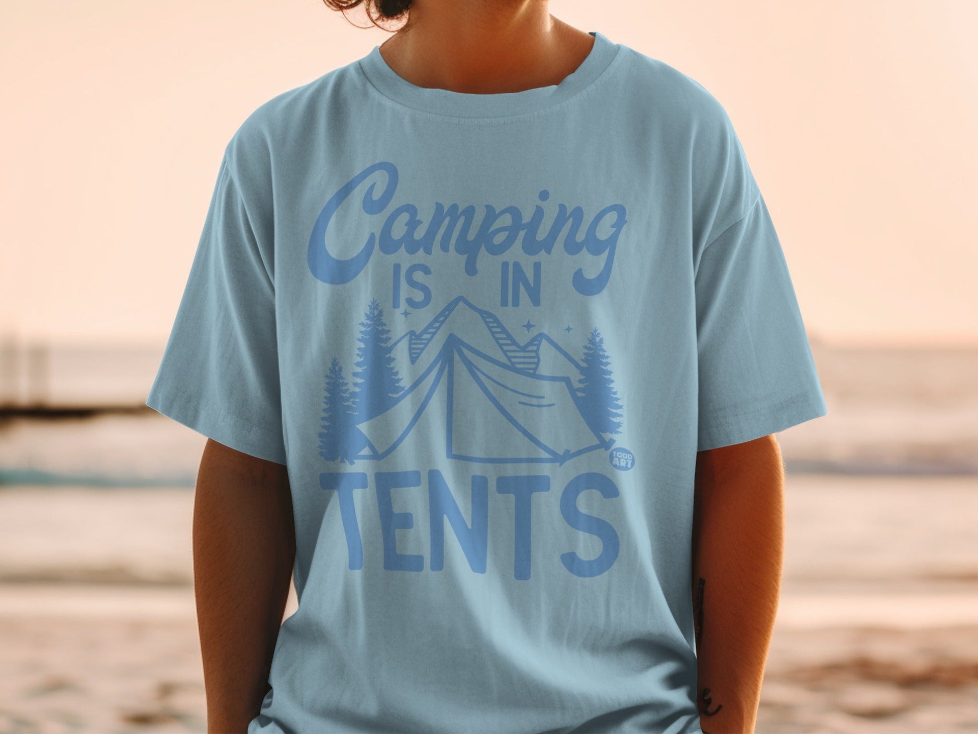 Light blue t-shirt with "Camping is in tents" text and mountain graphic.