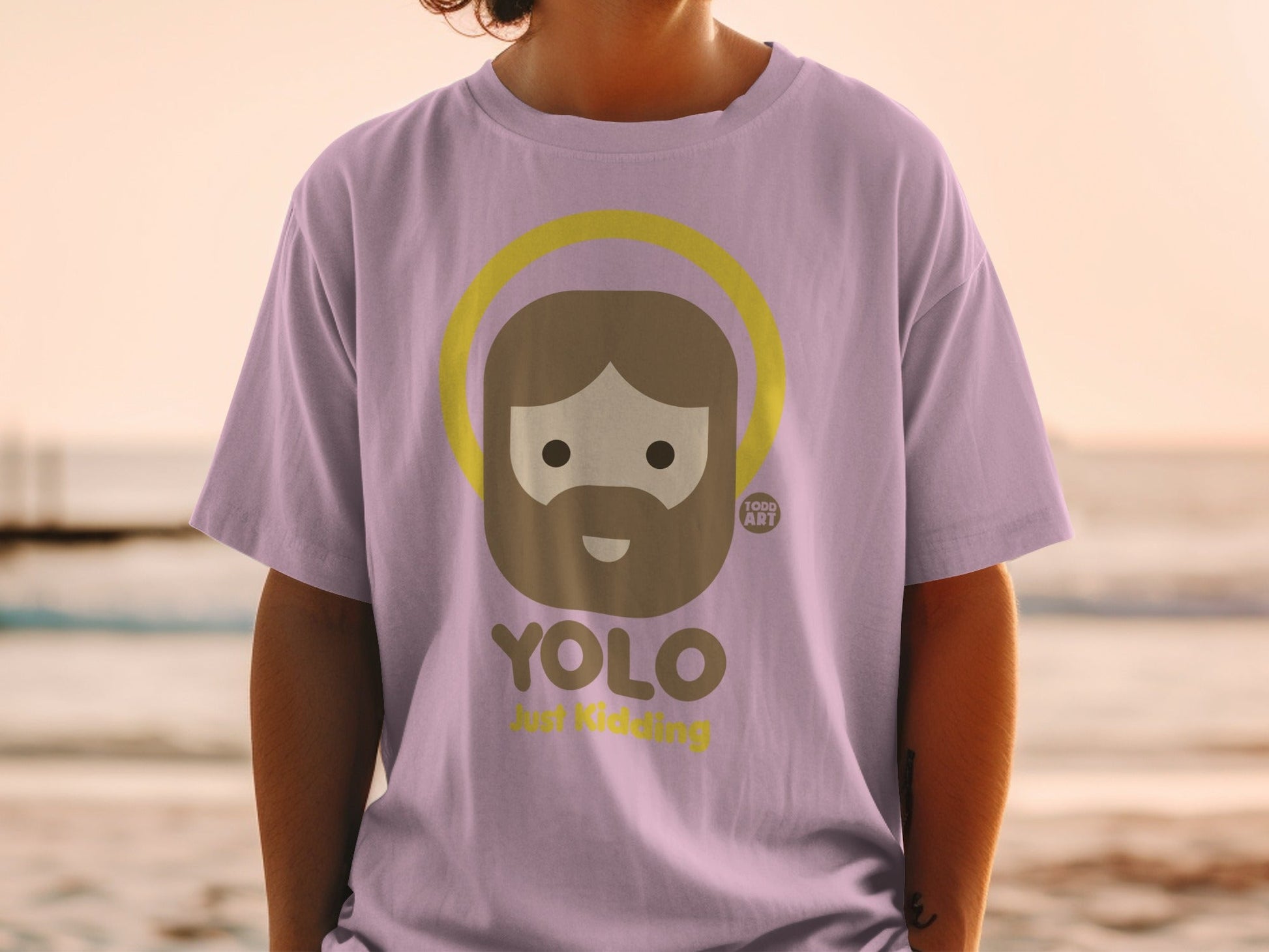 Purple t-shirt with "YOLO Just Kidding" and a cartoon Jesus graphic.
