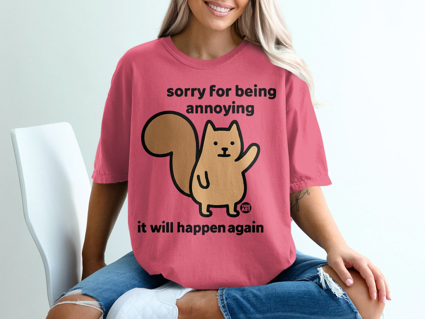 Pink t-shirt with a cartoon squirrel and text "sorry for being annoying it will happen again".