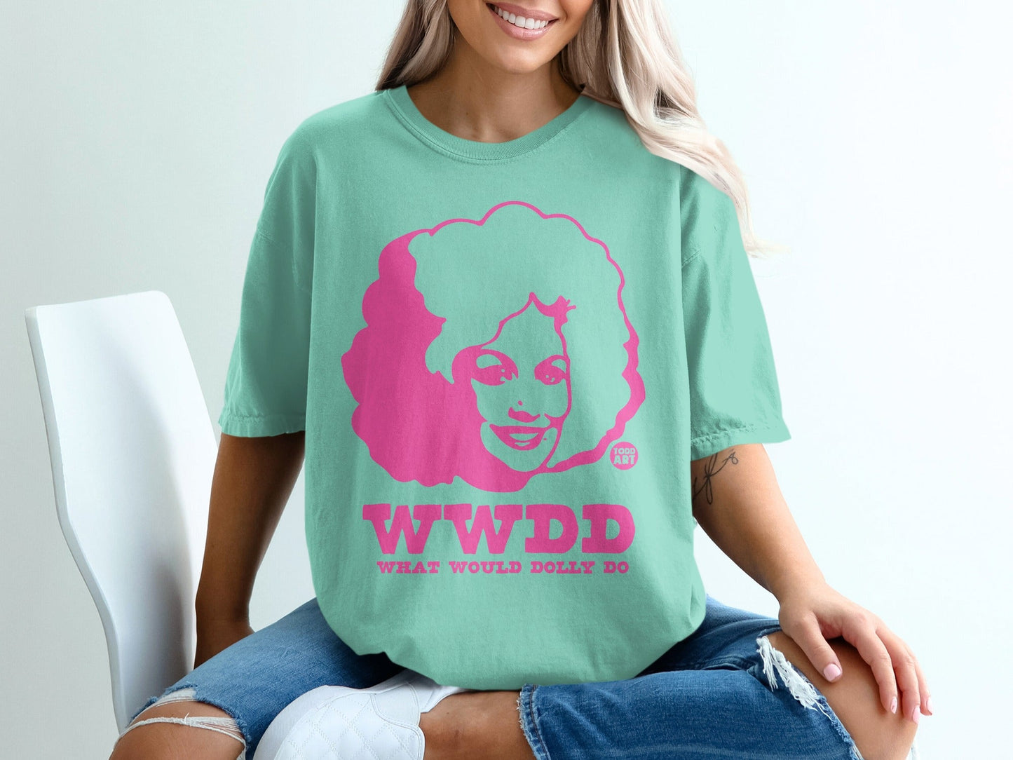 Teal t-shirt with pink "WWDD" text and Dolly Parton graphic.