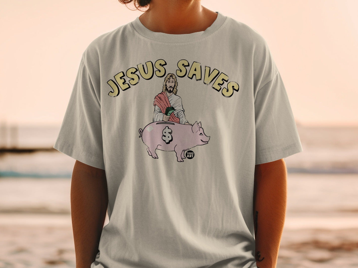 T-shirt with "Jesus Saves" and Jesus holding a pig with a dollar sign.