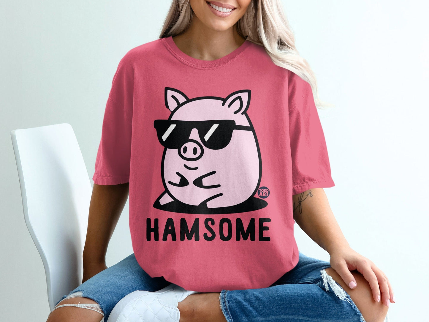 Pink t-shirt with cartoon pig wearing sunglasses and the text "HAMSOME".