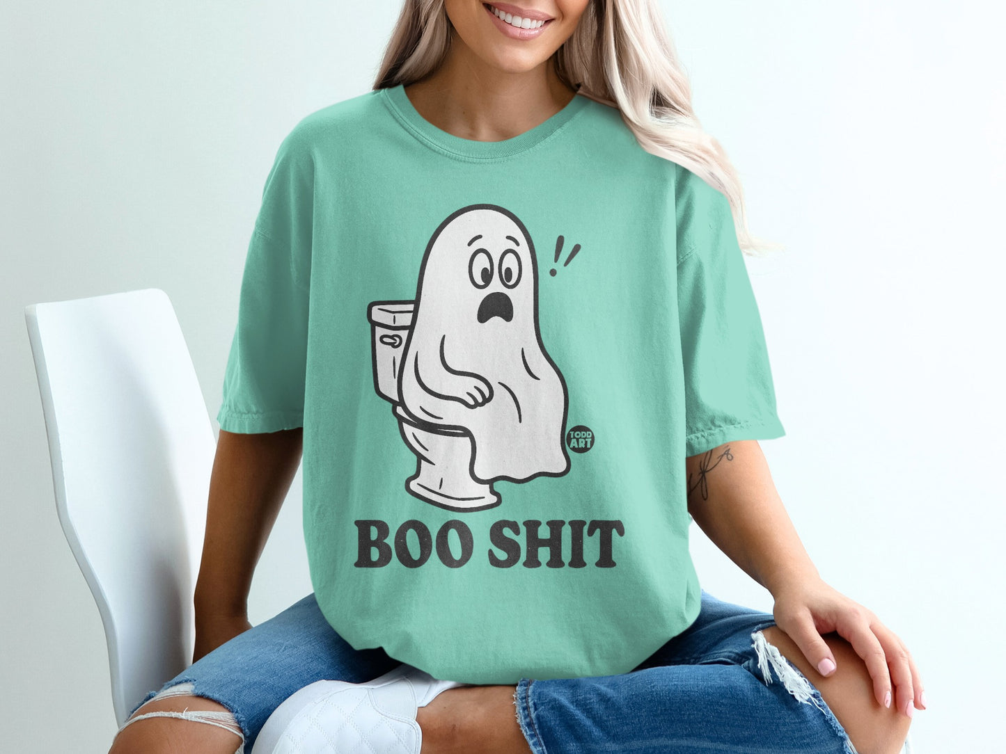 Ghost sitting on toilet, "Boo Shit" text, mint green t-shirt.