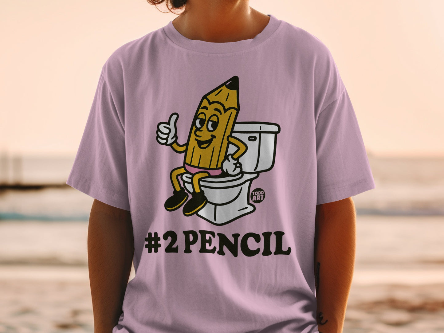 Pink t-shirt with a cartoon pencil giving a thumbs up on a toilet.