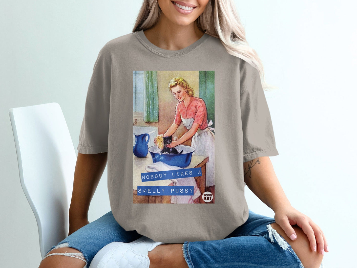 Woman in pink apron washes black cat in blue basin, "Nobody likes a smelly pussy" text.