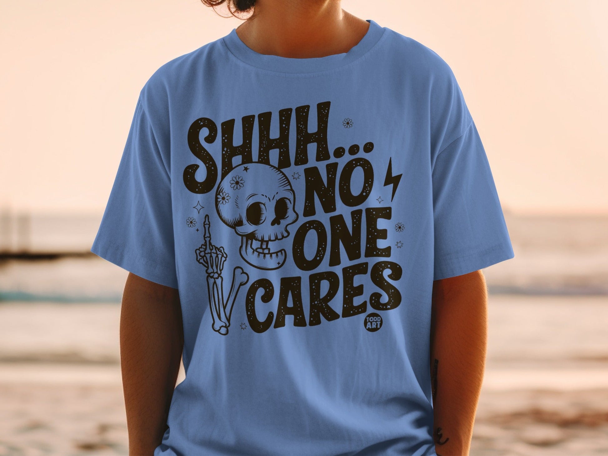 Blue t-shirt with "SHHH...NO ONE CARES" and skull graphic.