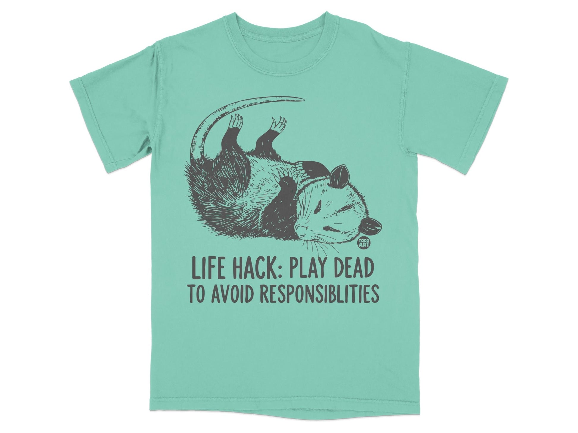 Opossum playing dead on a mint green t-shirt with "LIFE HACK: PLAY DEAD TO AVOID RESPONSIBILITIES" text.