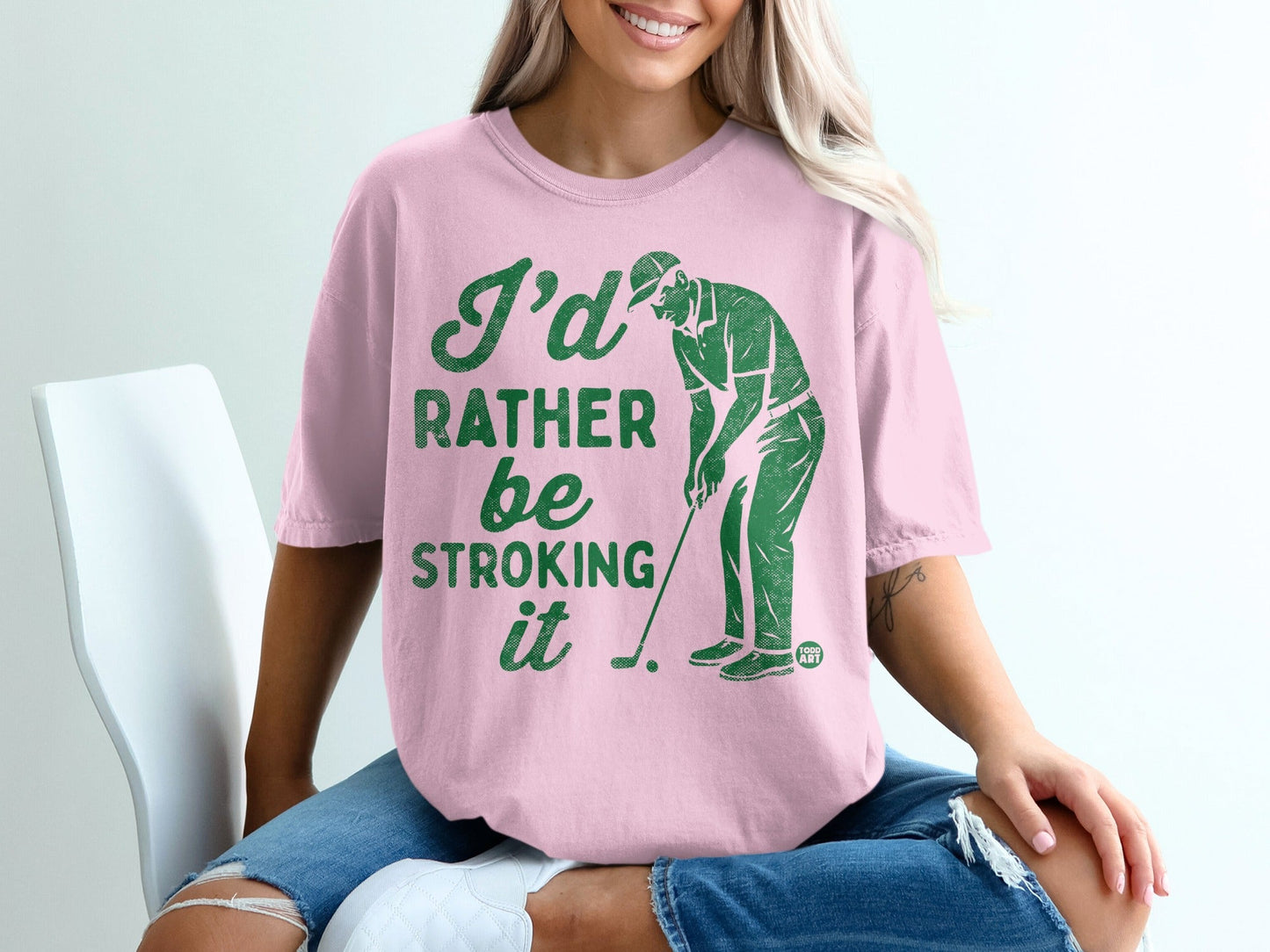 Pink t-shirt with "I'd rather be stroking it" and golfer graphic.
