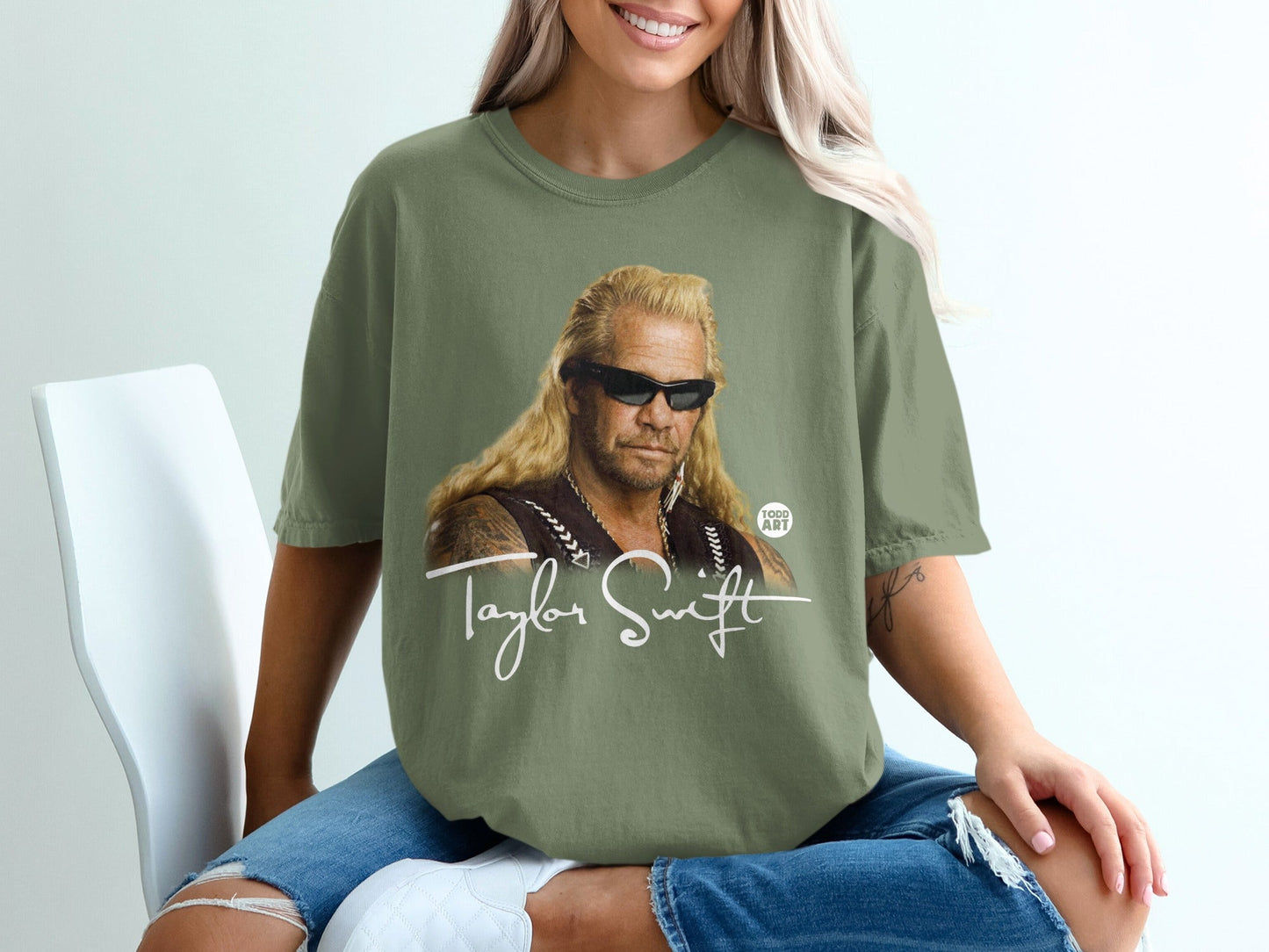 Woman in olive green t-shirt with "Dog the Bounty Hunter" graphic and Taylor Swift signature.