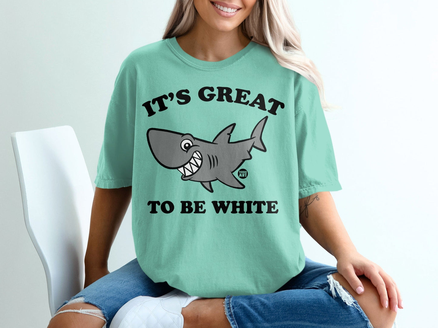 Teal t-shirt with "IT'S GREAT TO BE WHITE" text and a cartoon shark graphic.