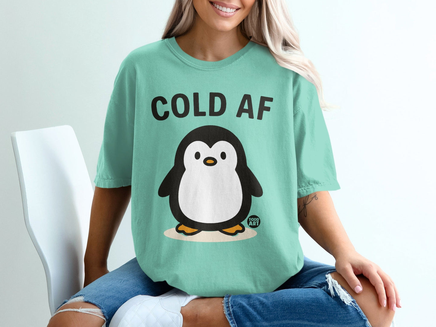 Mint t-shirt with cartoon penguin and text "COLD AF".