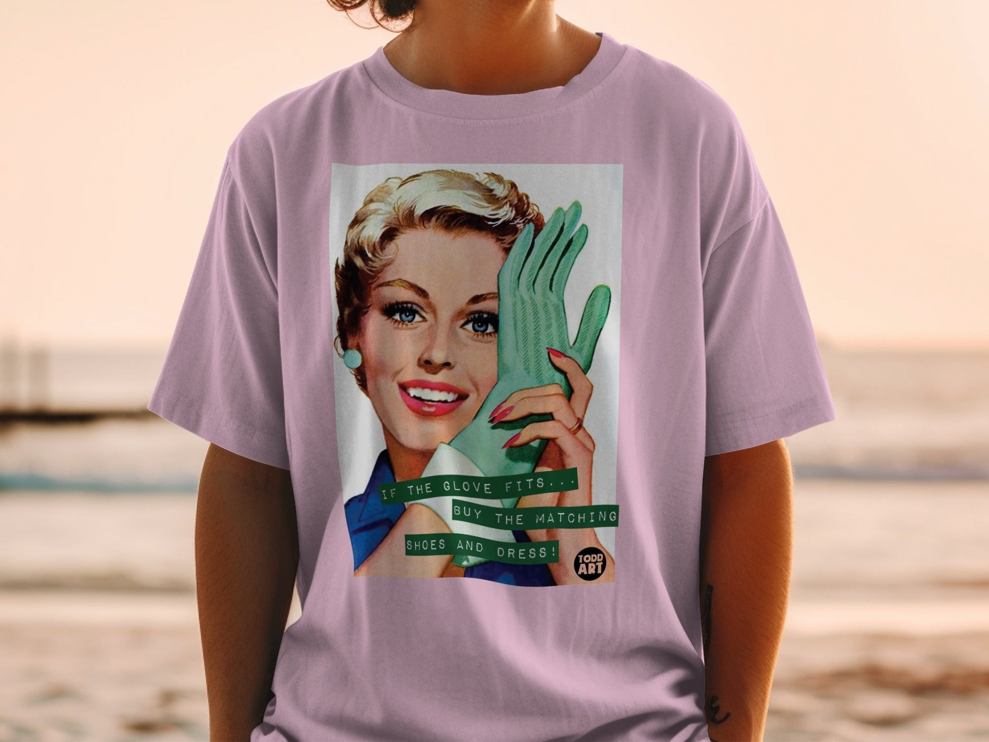 Woman in pink shirt wearing a vintage graphic t-shirt with a retro woman and text.