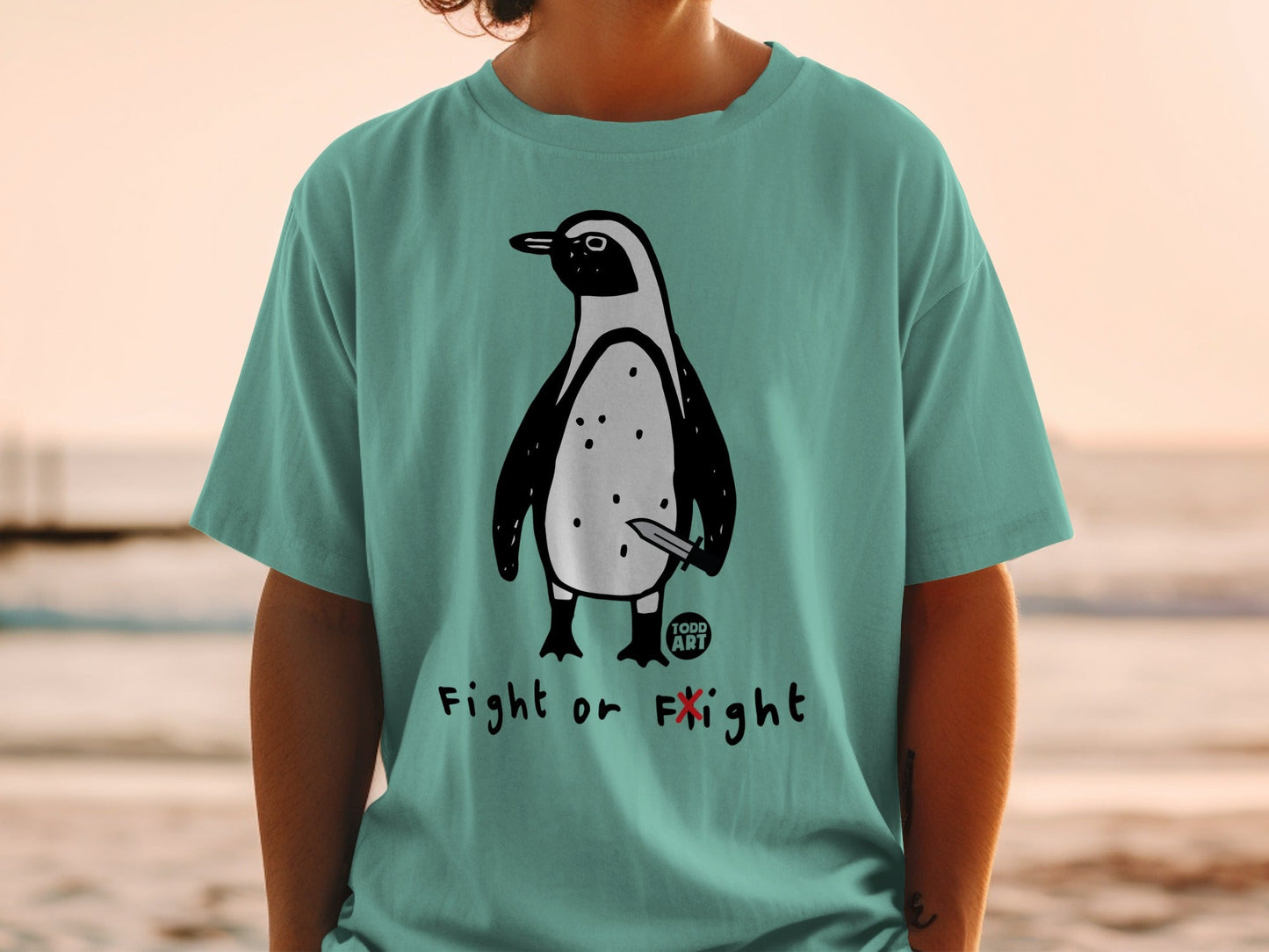 Teal t-shirt with a penguin holding a knife, text reads "Fight or Flight".