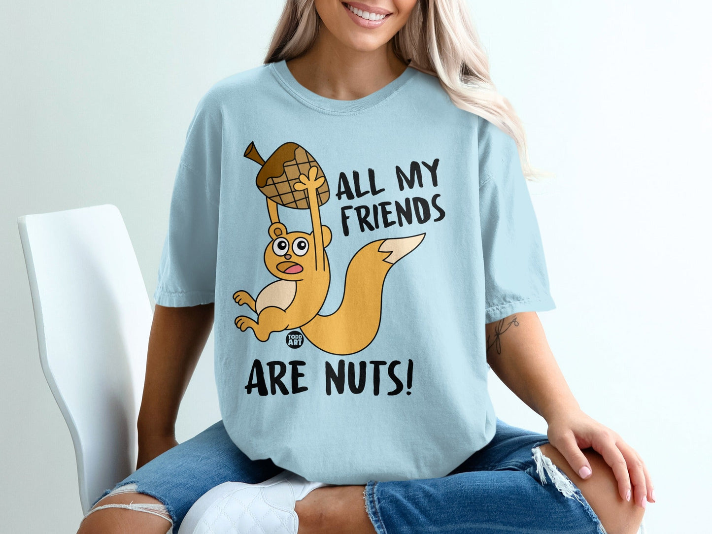 Light blue t-shirt with a cartoon squirrel and text that reads "All my friends are nuts!"