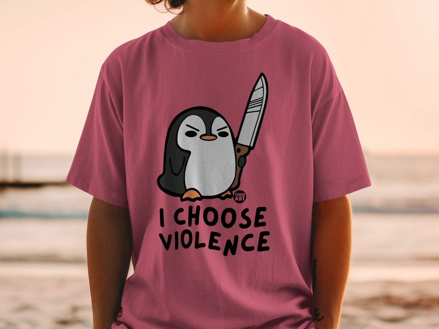 Pink t-shirt with cartoon penguin holding a knife and text "I CHOOSE VIOLENCE".