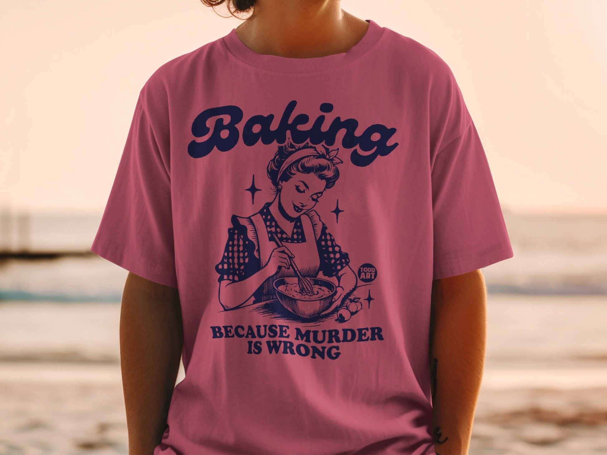 T-shirt with "Baking Because Murder is Wrong" text and retro baking illustration.