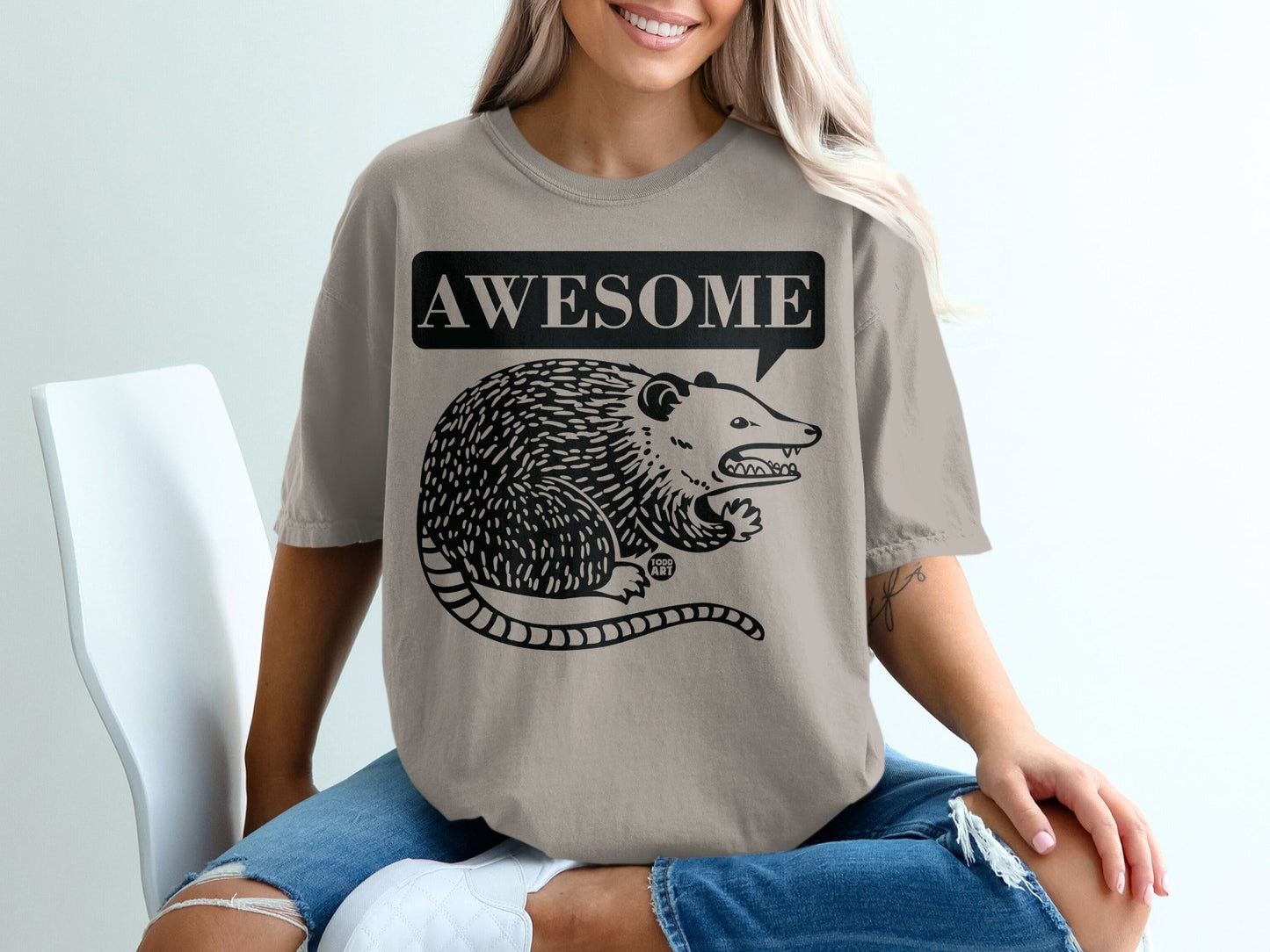 T-shirt with black line drawing of a possum and "AWESOME" speech bubble.