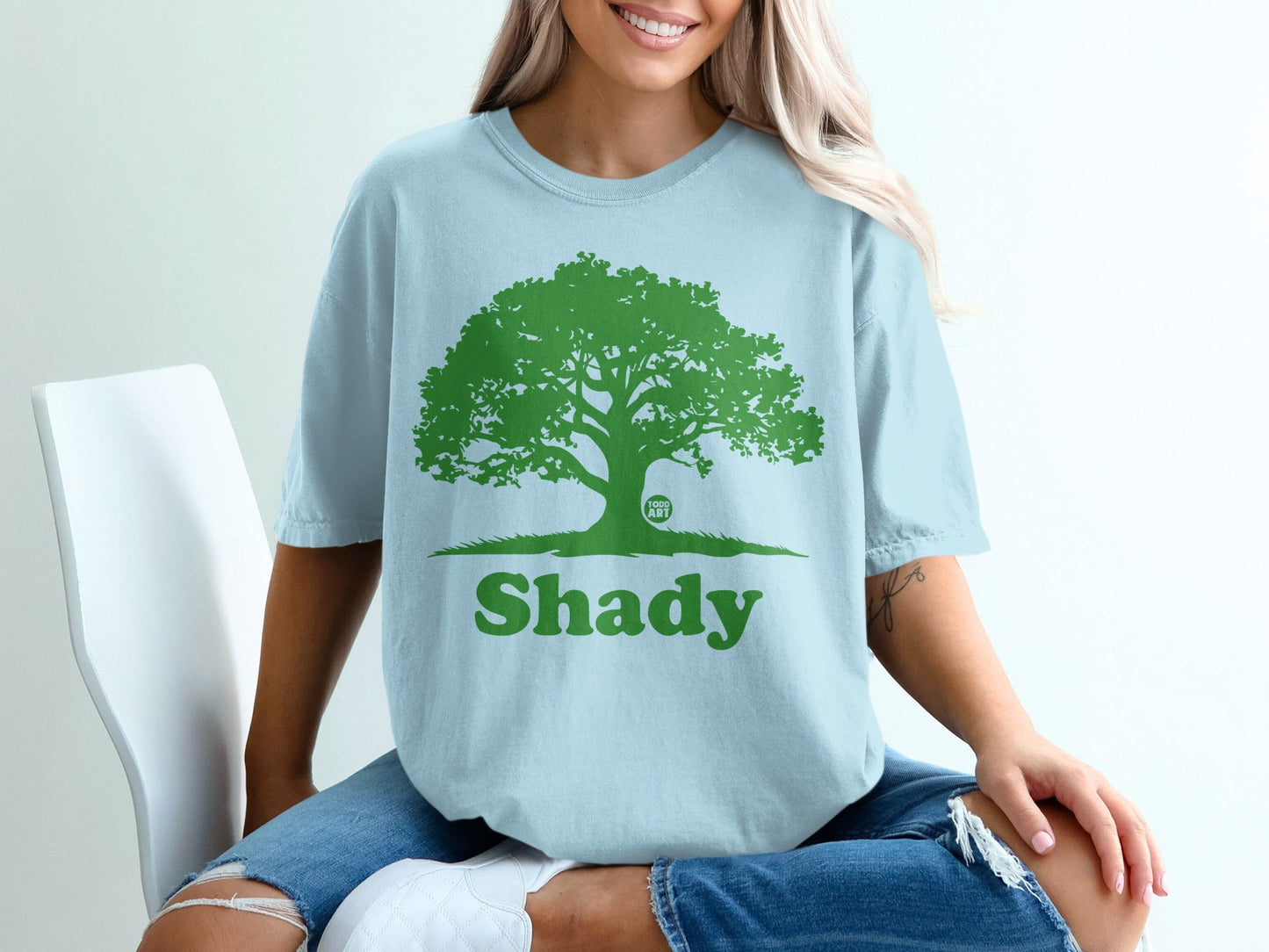 Light blue t-shirt with green tree graphic and "Shady" text.
