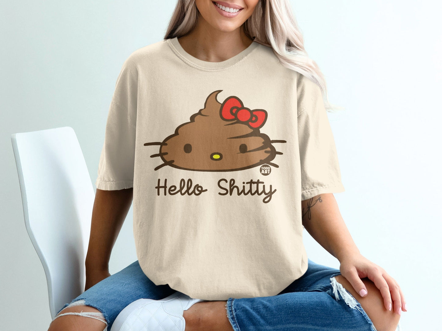 T-shirt with Hello Shitty poop emoji and red bow graphic.