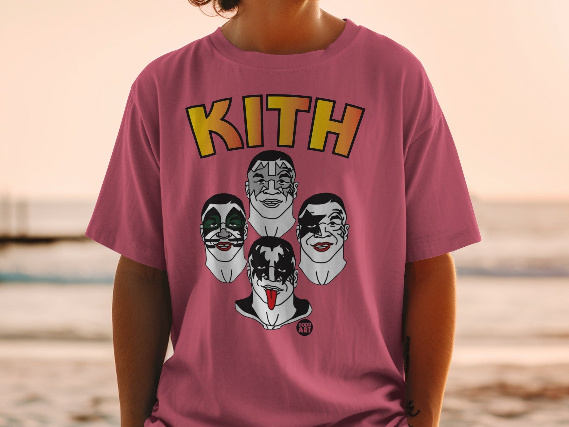 Pink Kith t-shirt featuring KISS band members' makeup designs and "1000 ART" logo.