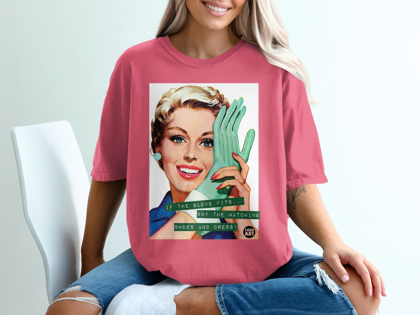 Woman wearing pink t-shirt with vintage graphic of woman holding green glove.