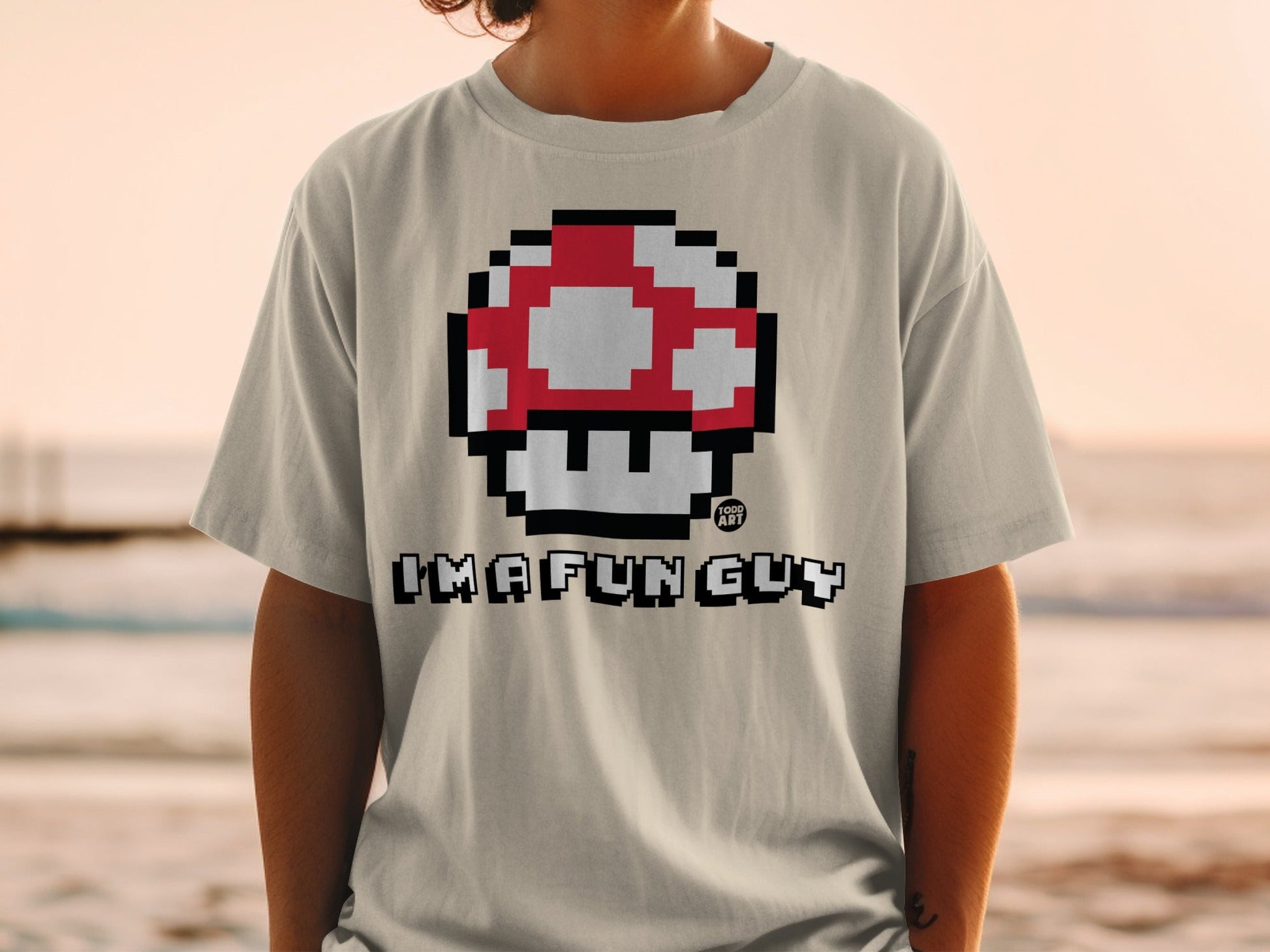 Light gray t-shirt with red and white pixelated mushroom and "I'M A FUN GUY" text.