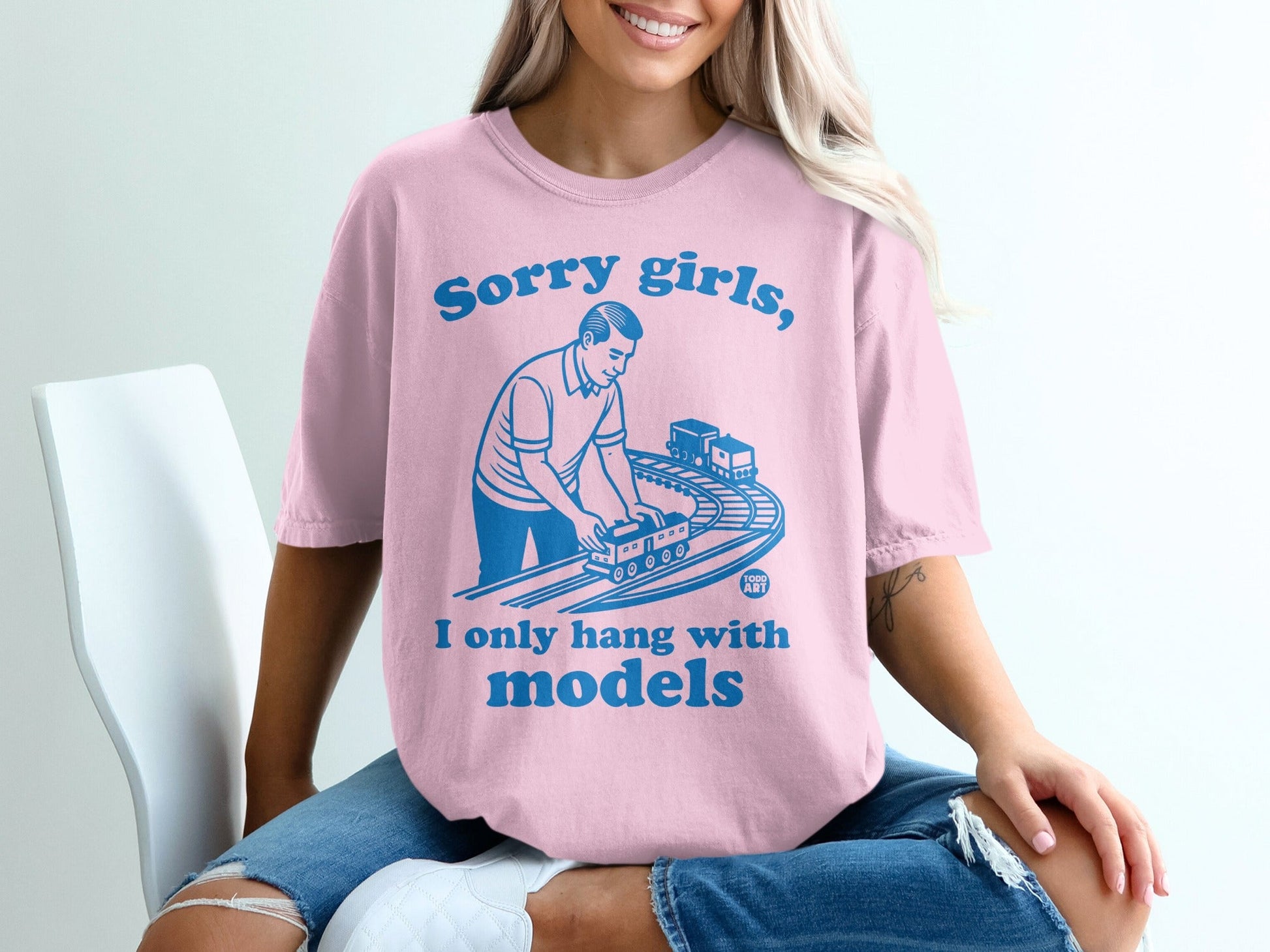 Pink t-shirt with "Sorry girls, I only hang with models" and toy train graphic.