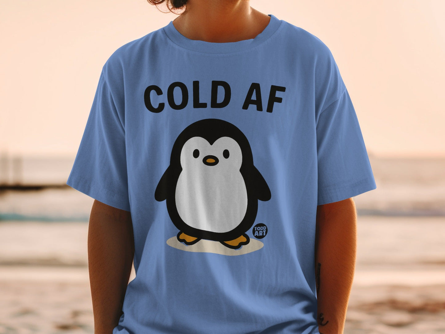 Blue t-shirt with "COLD AF" text and a cartoon penguin.