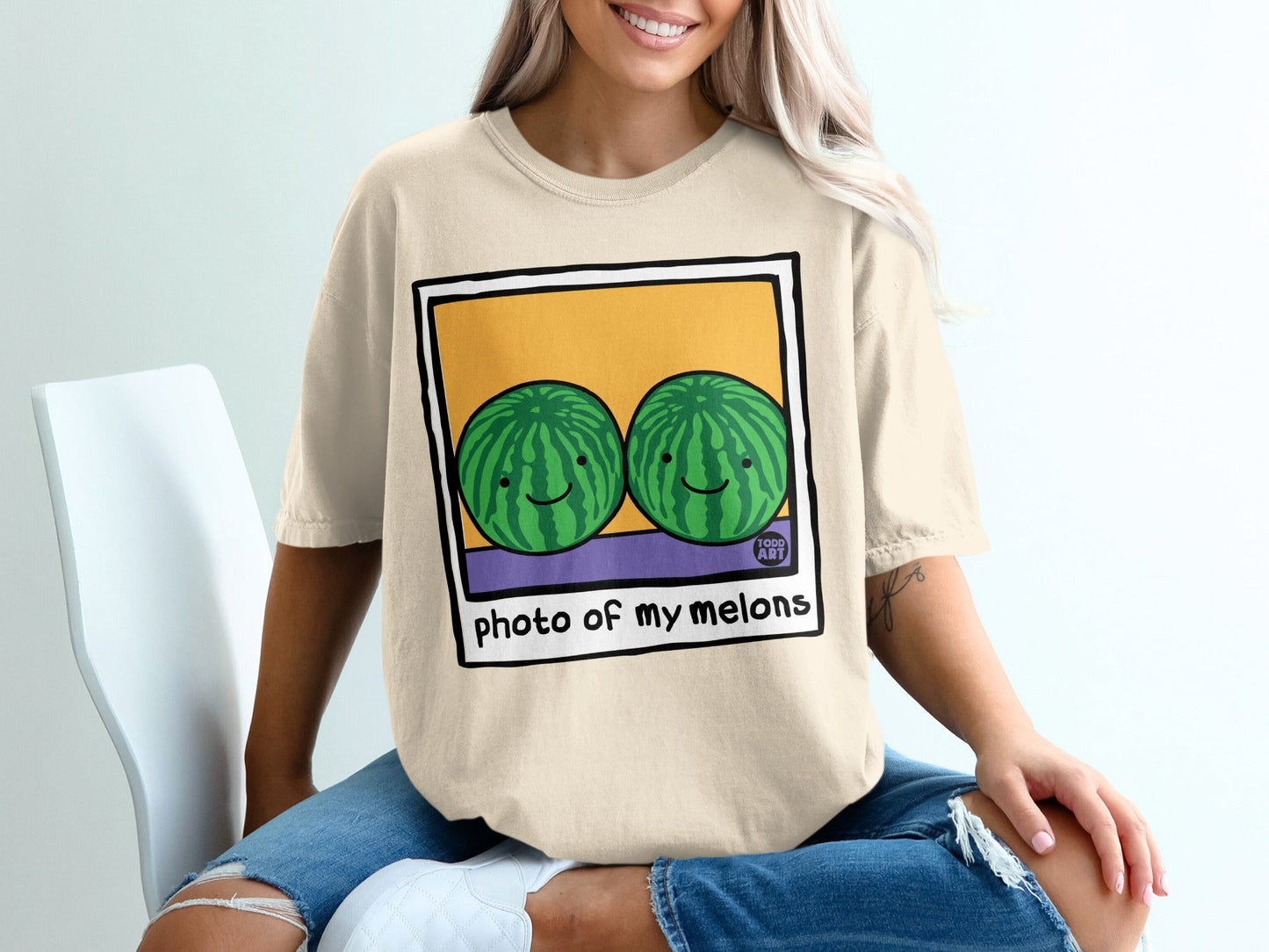 Two cartoon watermelons with smiling faces on a t-shirt that says "photo of my melons".
