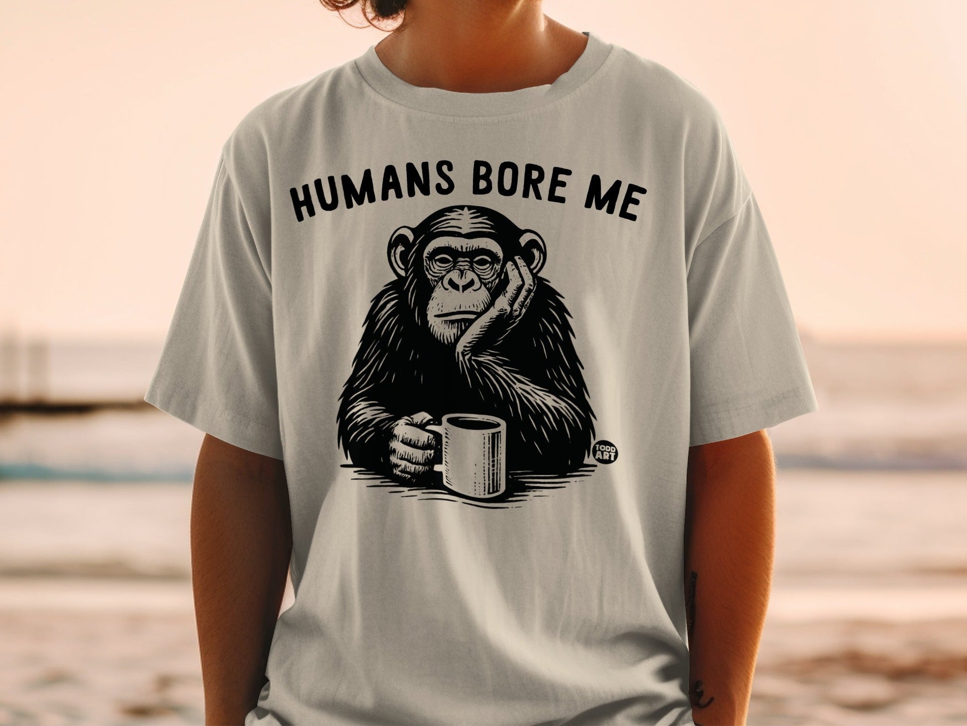 Black and white chimpanzee wearing shirt that says "HUMANS BORE ME".