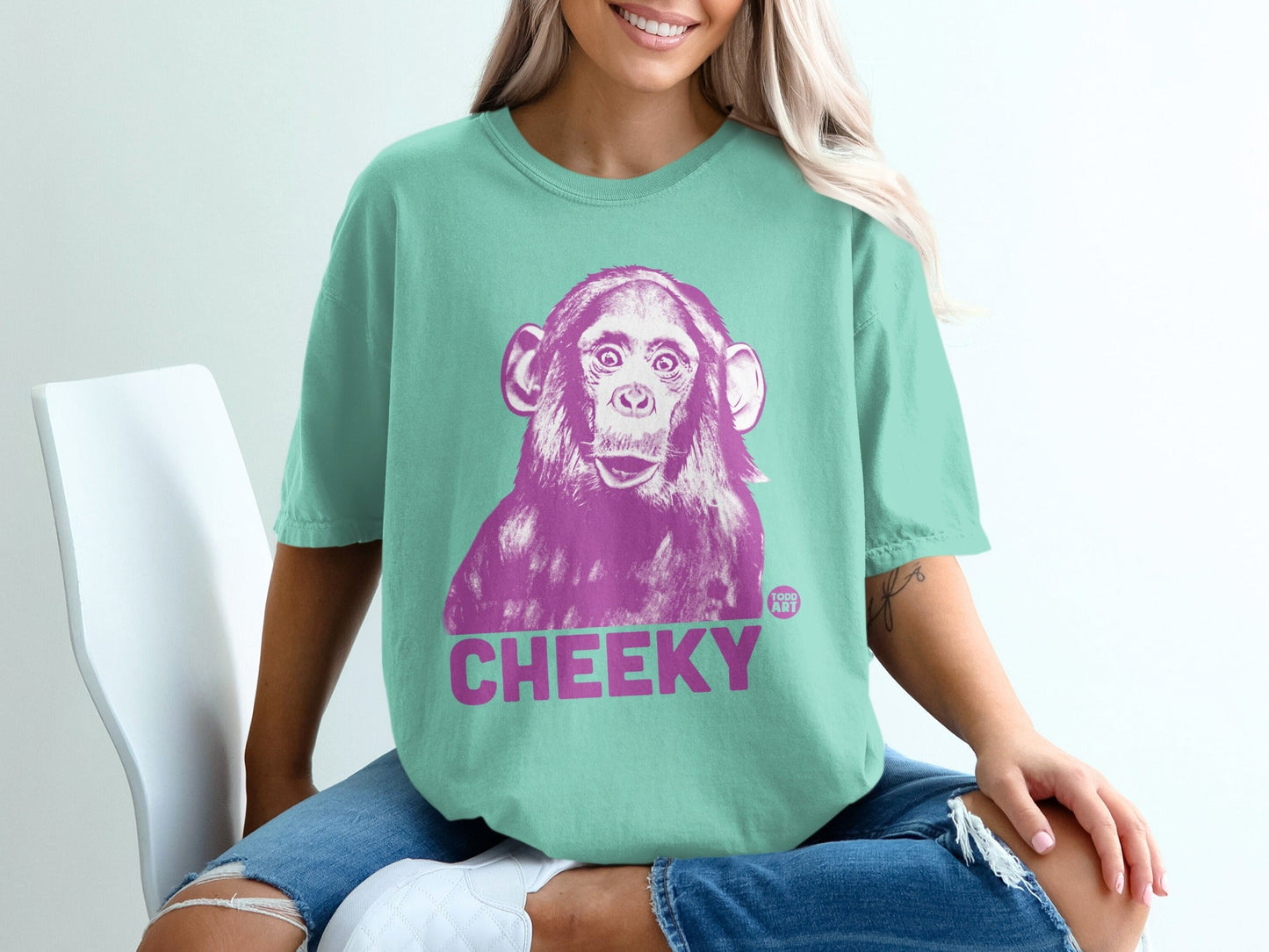 Teal t-shirt with a large purple monkey illustration and the word CHEEKY.