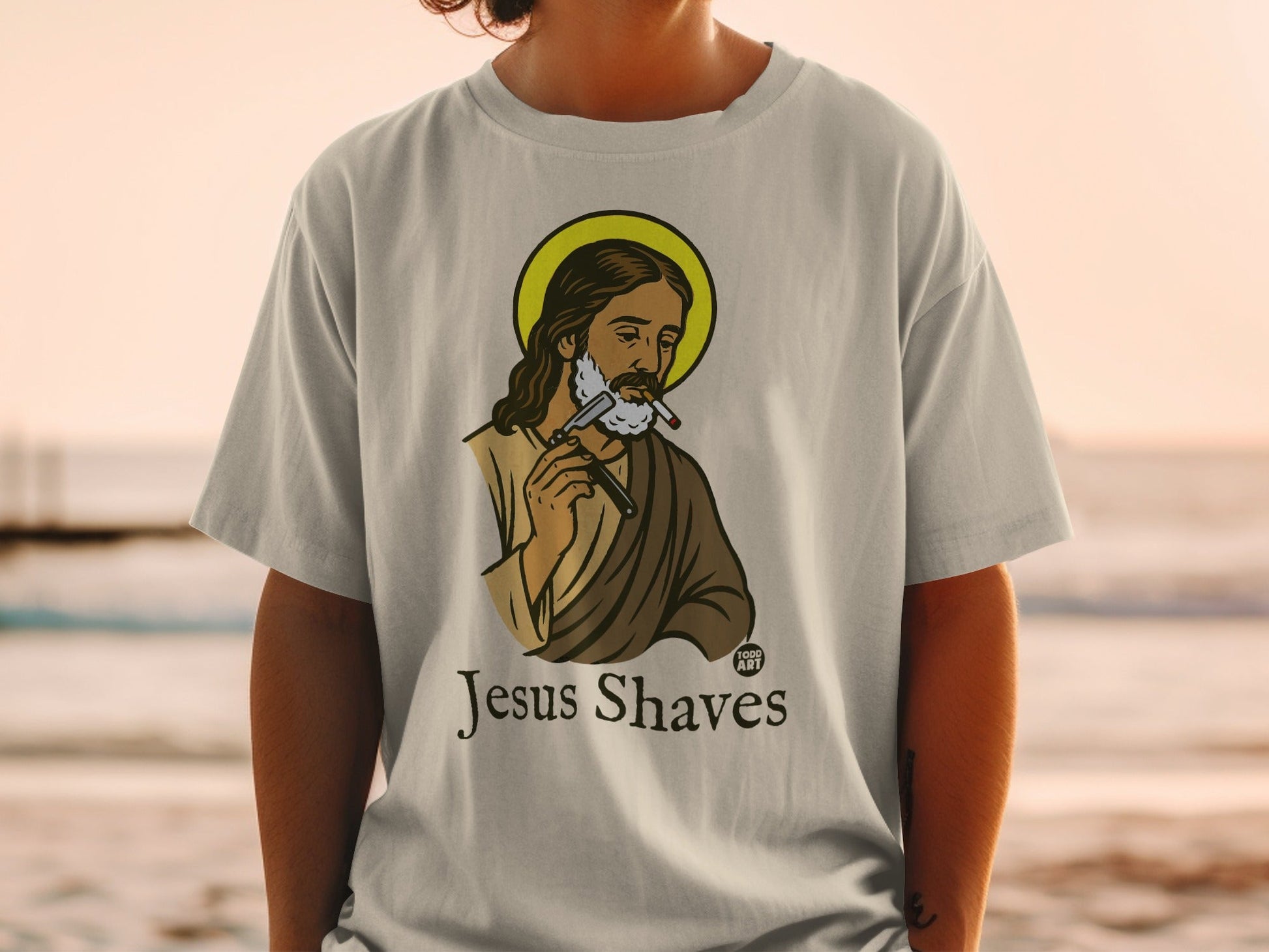 Jesus wearing a halo shaves with a razor, with text "Jesus Shaves".