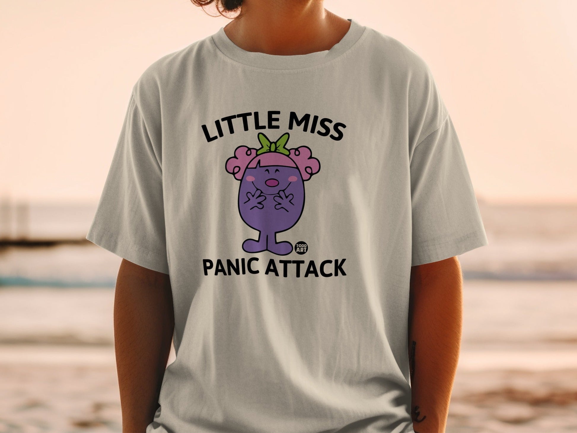 T-shirt with "Little Miss Panic Attack" text and cartoon character.