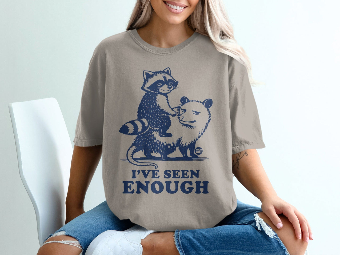 Graphic t-shirt with raccoon riding a possum, text reads "I'VE SEEN ENOUGH".