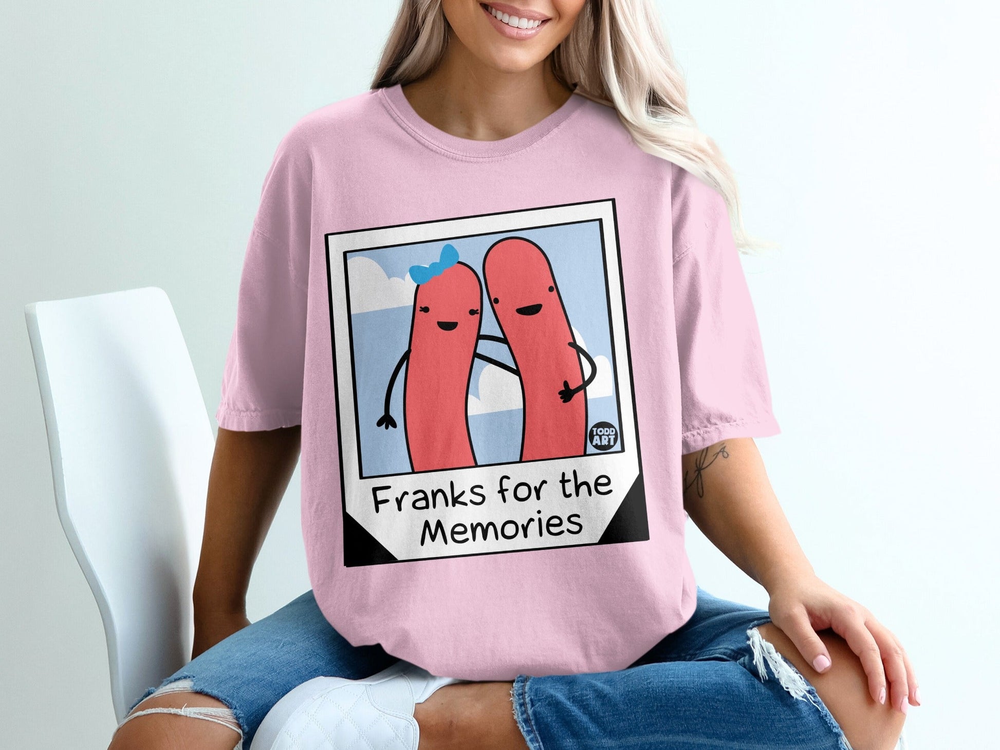 Pink t-shirt with cartoon hot dogs and "Franks for the Memories" text.
