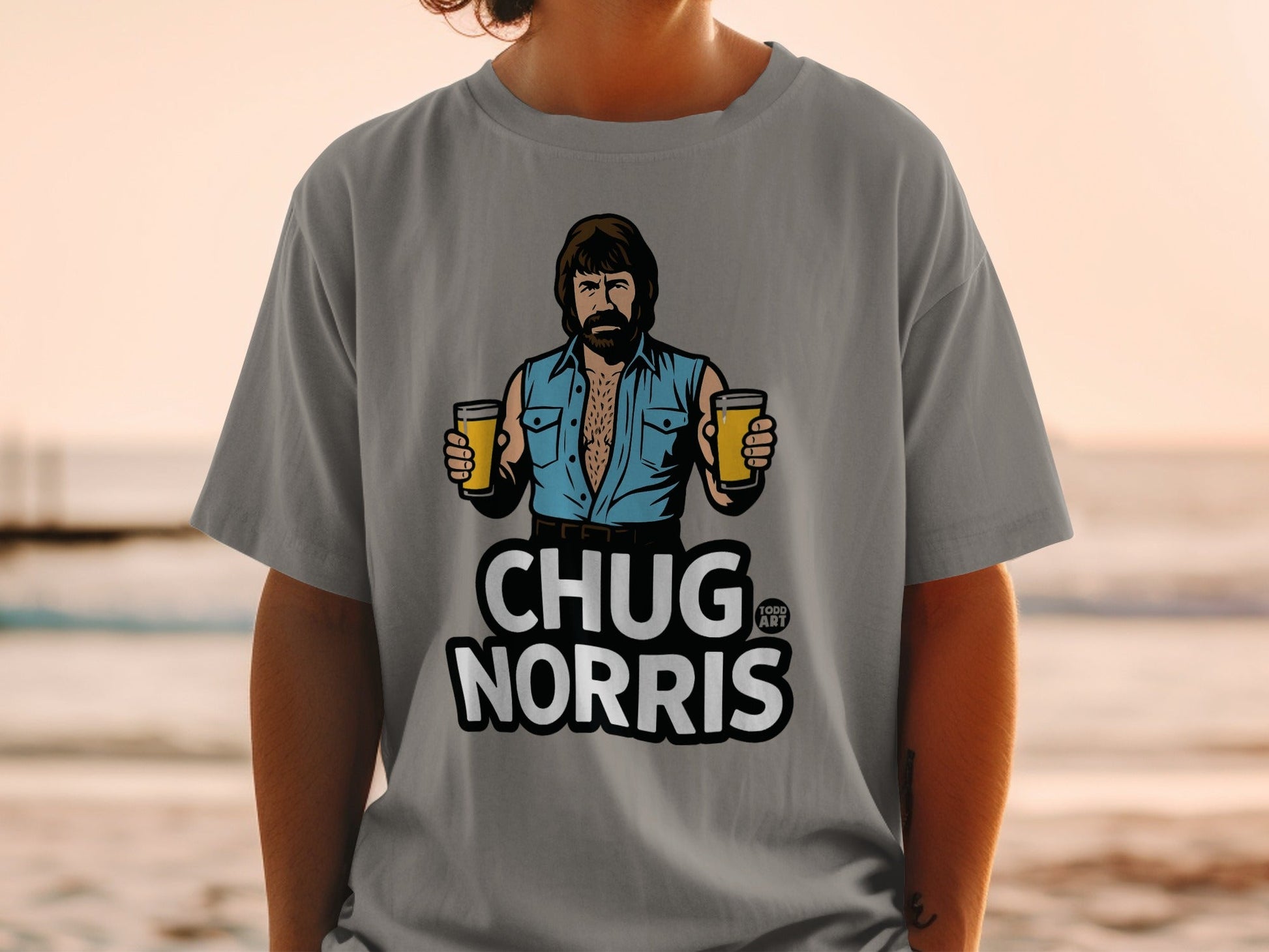 Gray t-shirt featuring Chuck Norris holding two beers, text reads "CHUG NORRIS".