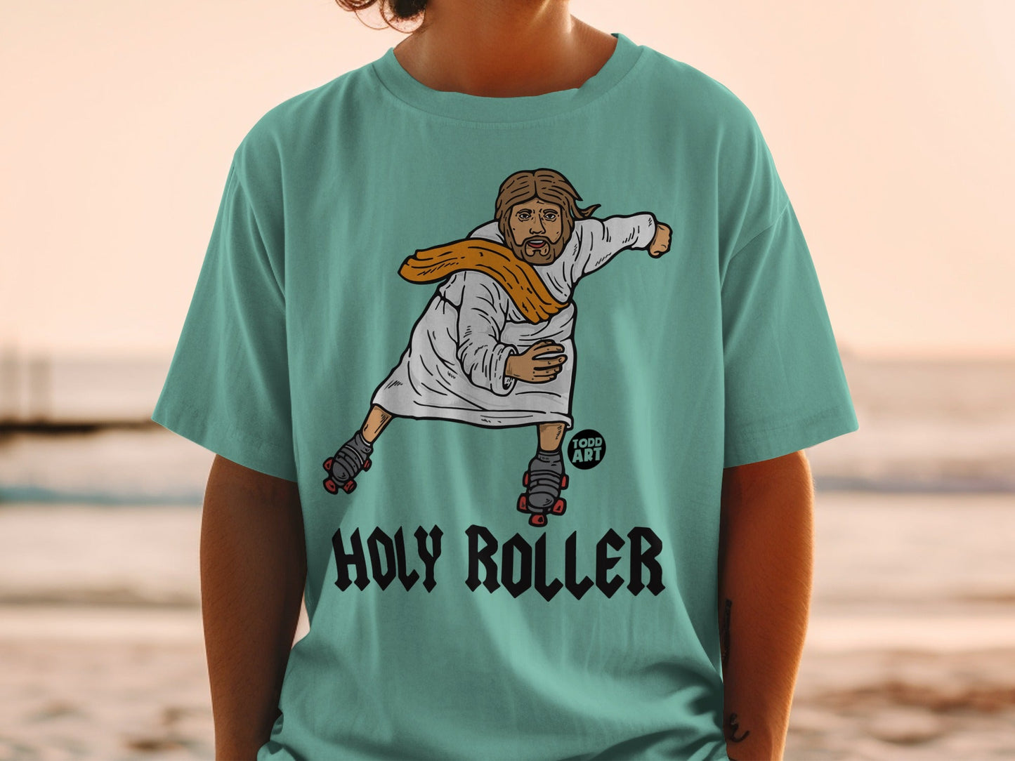 T-shirt with Jesus wearing roller skates and a sash, text "HOLY ROLLER".