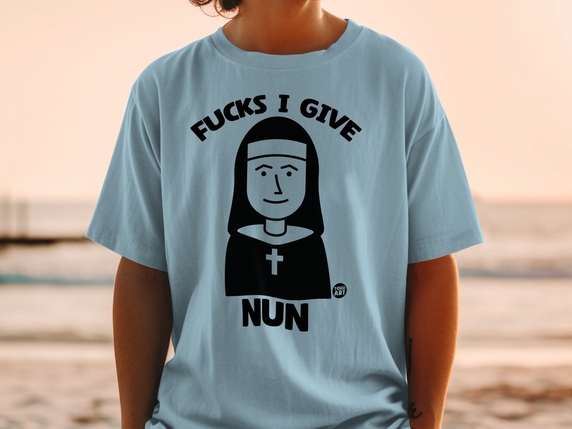 Blue t-shirt with "FUCKS I GIVE NUN" graphic of a nun.
