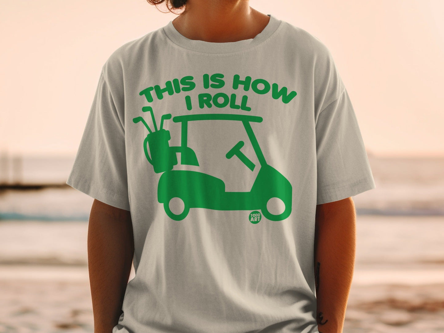 Green golf cart graphic with "This is how I roll" text on a t-shirt.