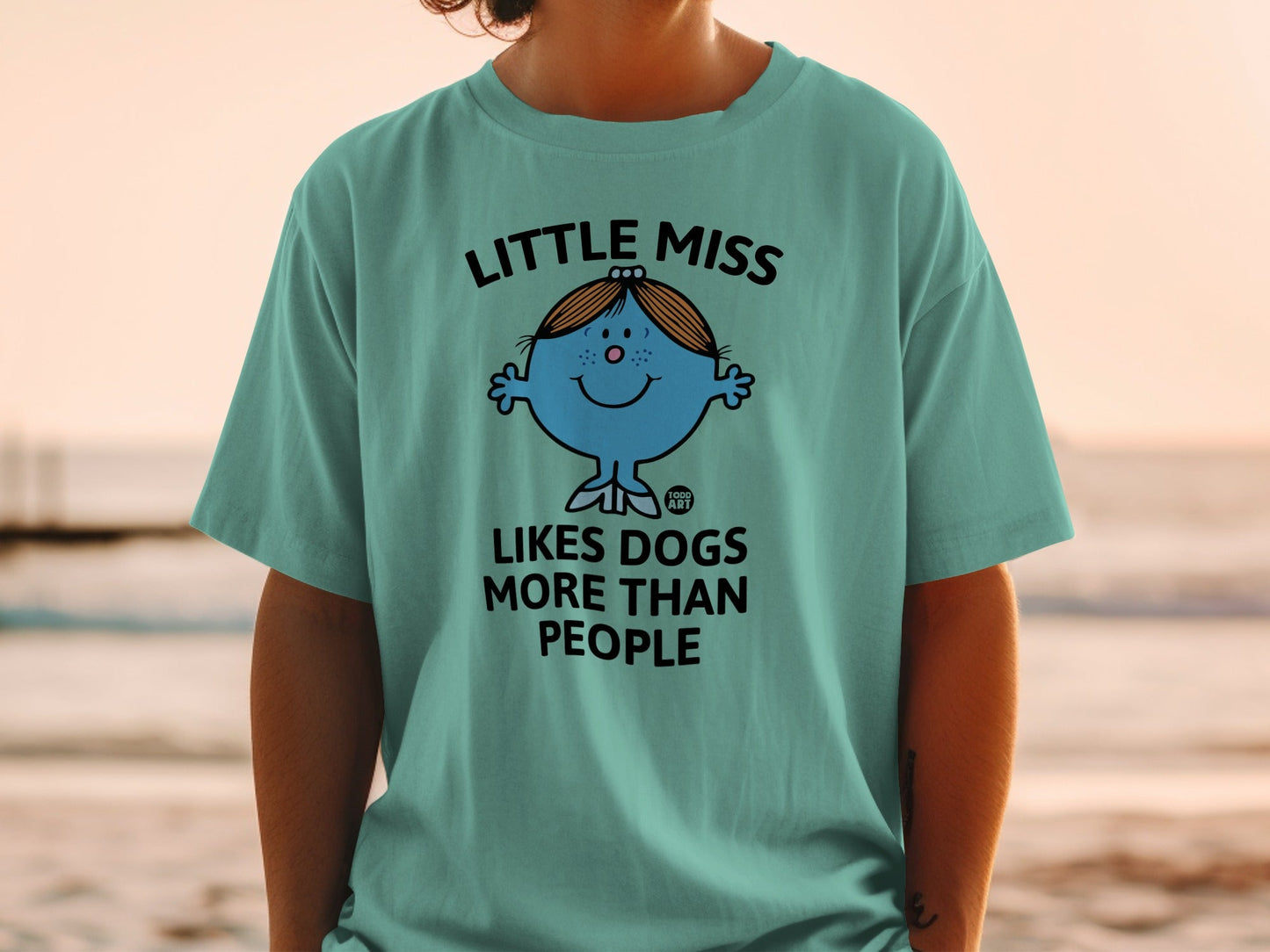 Blue cartoon character "Little Miss" t-shirt with text "LITTLE MISS LIKES DOGS MORE THAN PEOPLE".